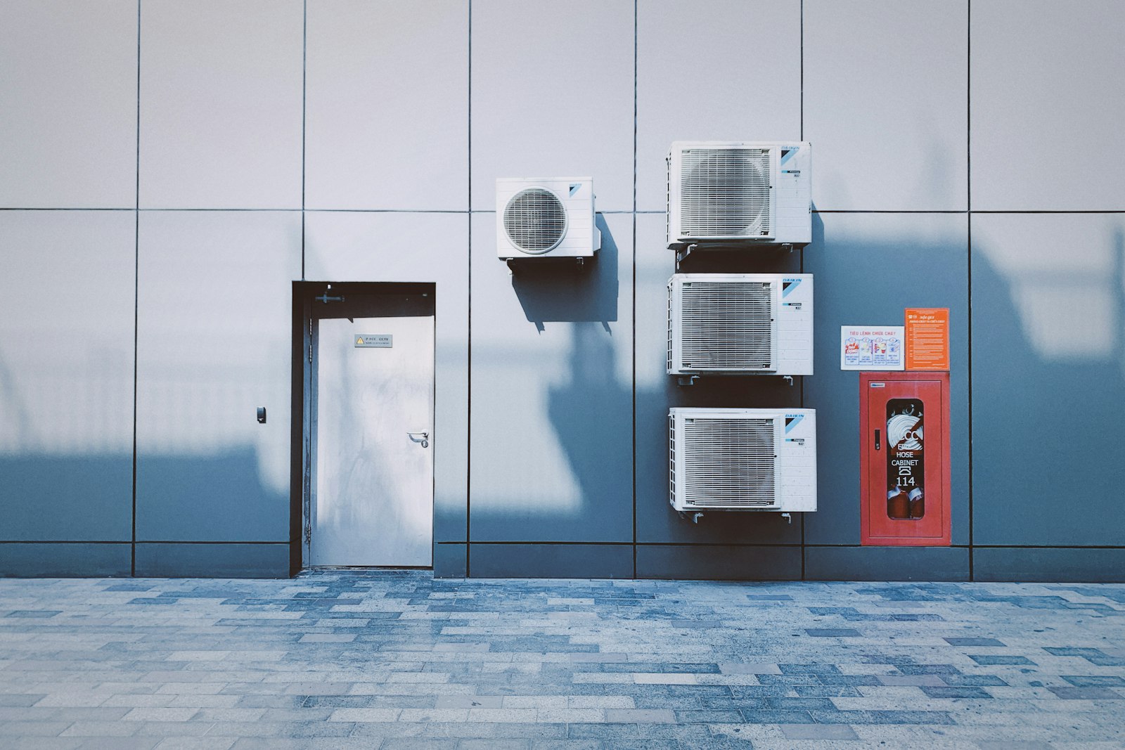 Multiple commercial air conditioning units mounted on a building wall