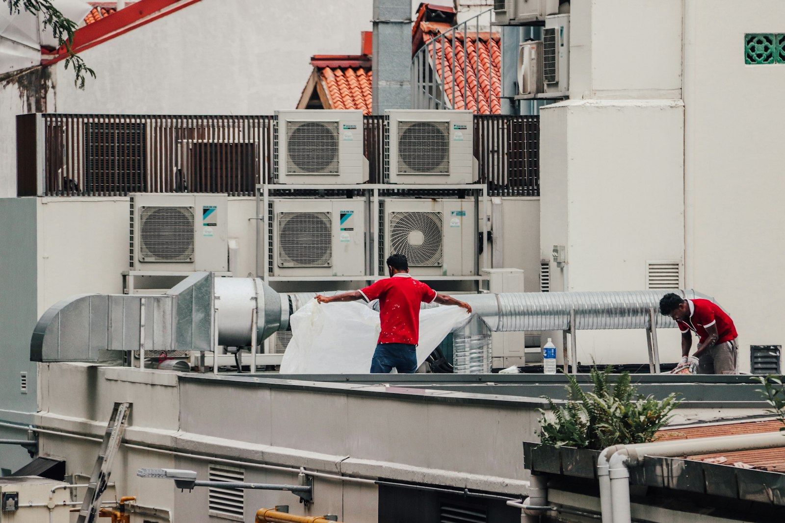 AP Heating & Cooling Systems crew servicing rooftop air conditioning ductwork